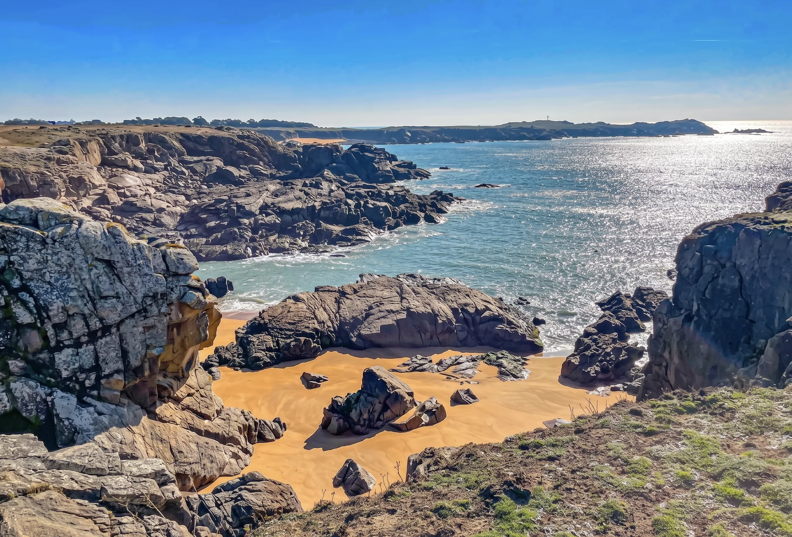 Crique sauvage de l'Île d'Yeu avec plage de sable doré entourée de rochers granitiques et côte atlantique découpée