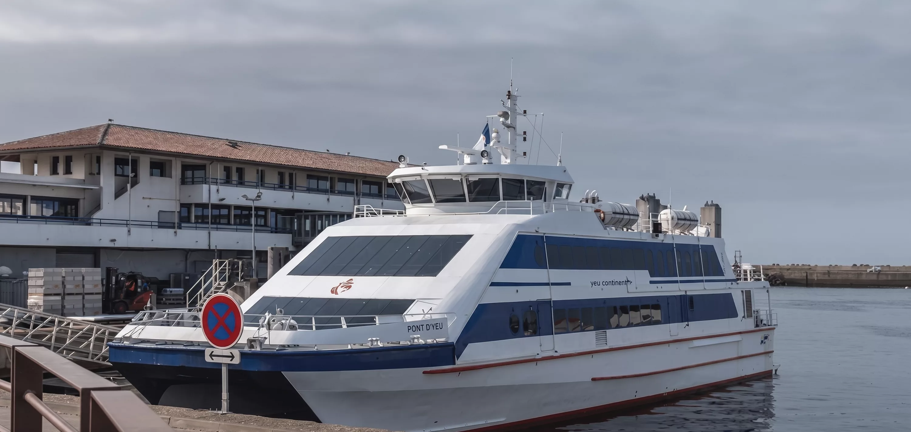 Ferry de passagers blanc et bleu amarré au port de Fromentine pour la traversée vers l'Île d'Yeu, Vendée