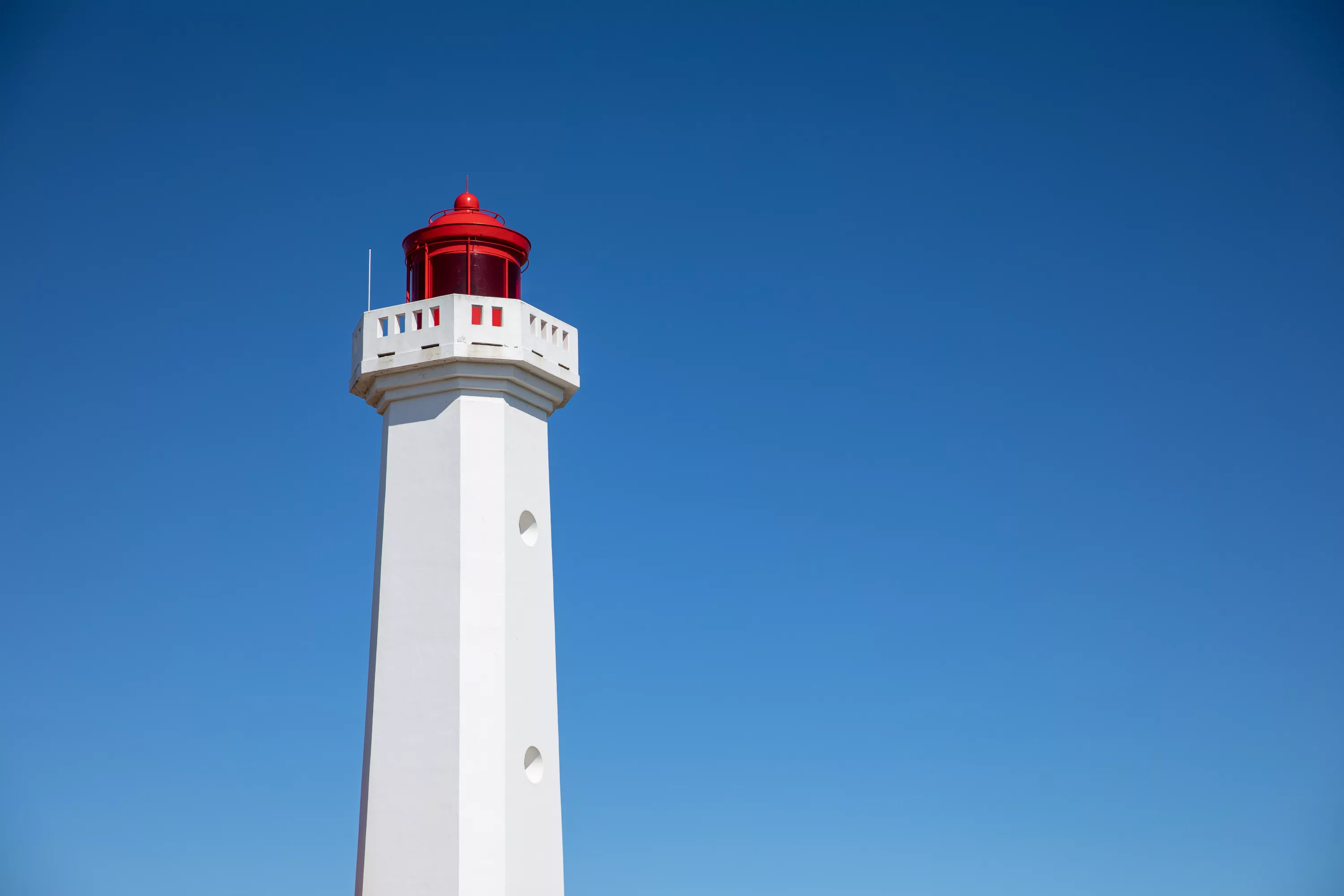Phare des Corbeaux - à lanterne rouge de l'Île d'Yeu sous un ciel bleu azur, monument emblématique de la côte vendéenne
