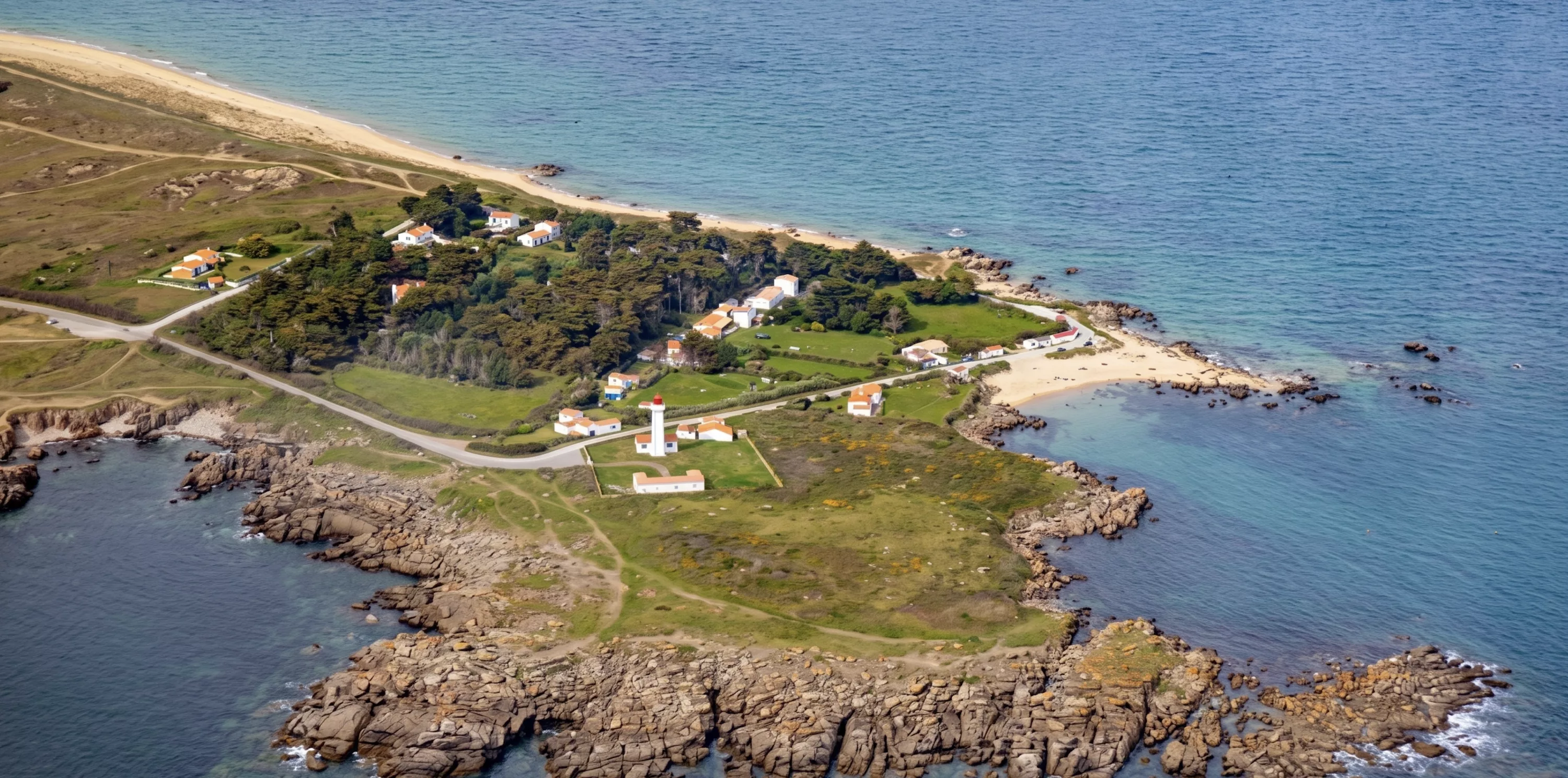 Vue aérienne de la Pointe du But et son phare sur l'Île d'Yeu, côte rocheuse et végétation verdoyante face à l'océan Atlantique
