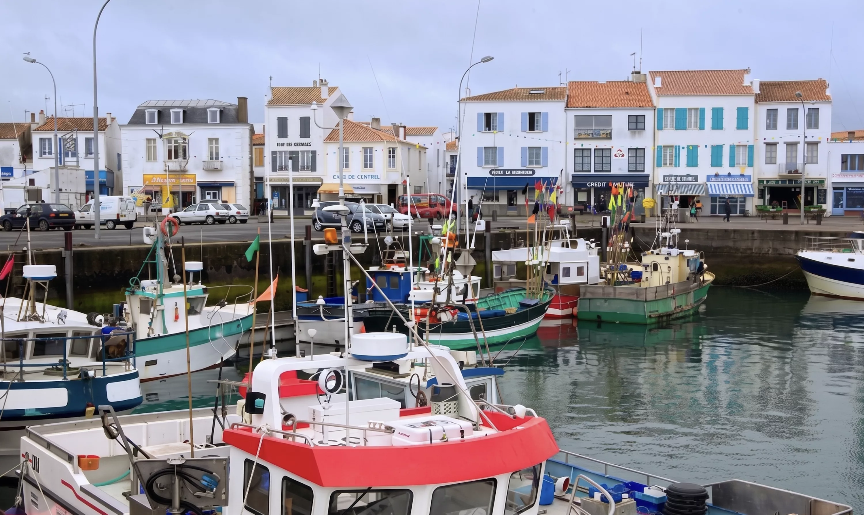 Port de Port-Joinville à l'Île d'Yeu avec bateaux de pêche colorés amarrés et maisons blanches en arrière-plan