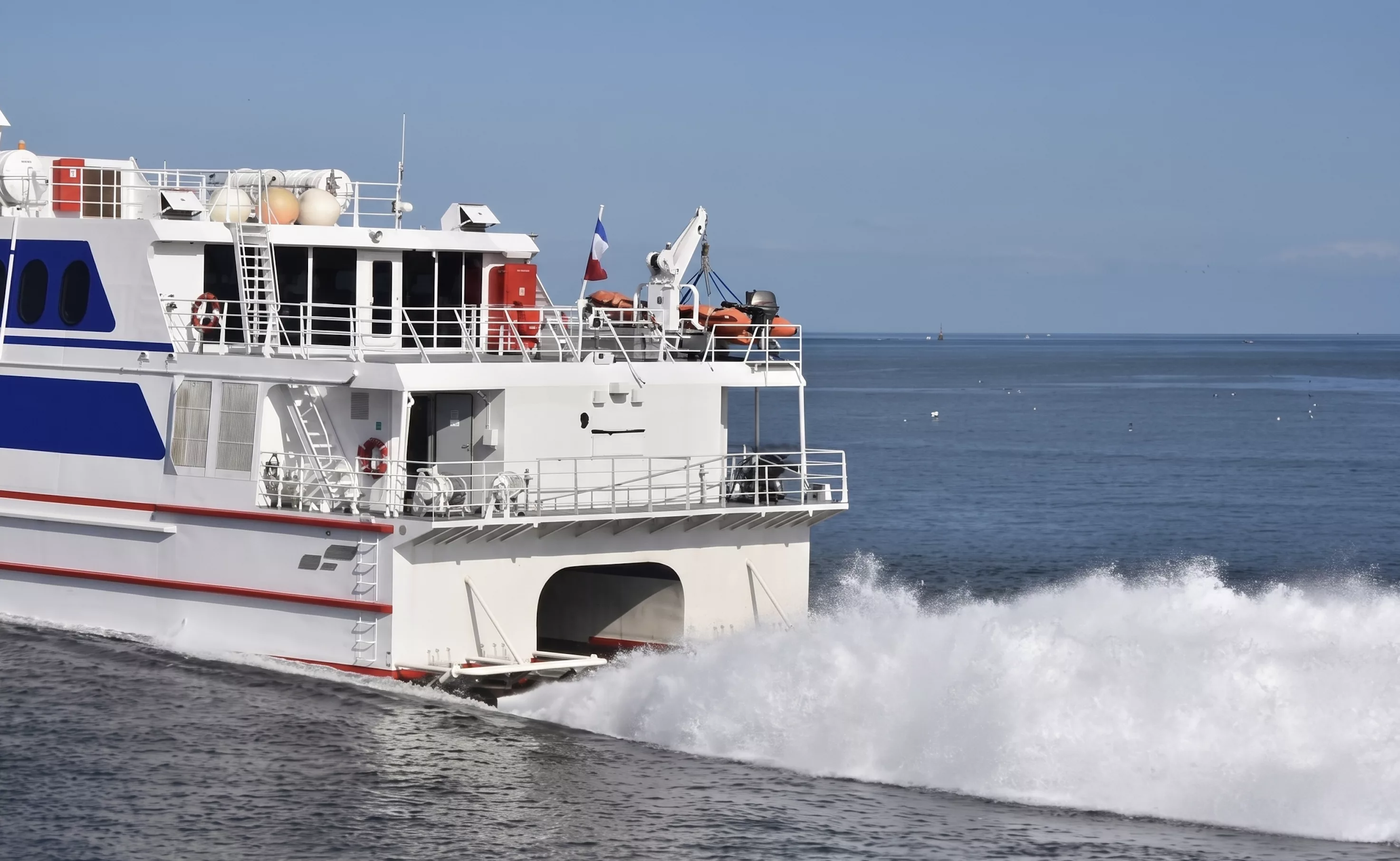 Catamaran à grande vitesse naviguant vers l'Île d'Yeu avec écume blanche, traversée maritime depuis la Vendée